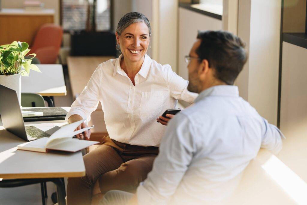 Business partners sitting at desk and discussing business strategy. Entrepreneurs doing discussion on new ventures in office.